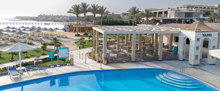 Die moderne Hotelanlage des SUNRISE Azalea Aqua Park Resort erstreckt sich entlang des Strandes. Palmen und das blaue Meer prägen die Kulisse.