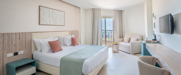 Die helle Suite des SUNRISE Azalea Aqua Park Resort ist in modernen Beigetönen gestaltet. Vom Zimmer öffnet sich der Blick auf das Meer.