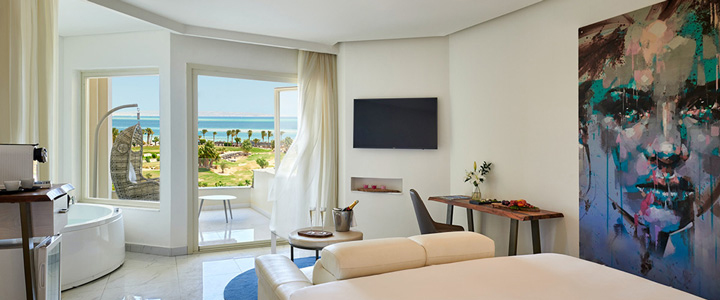 Die moderne, helle Suite des Steigenberger Pure Lifestyle bietet einen weiten Blick über Palmen und die grüne Landschaft bis zum Meer.
